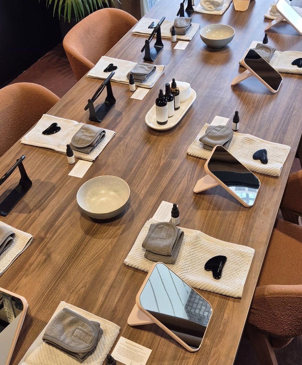 Mesa preparada para la masterclass presencial en Torrevieja: espejo, toalla, gua sha y sérum para cada alumna